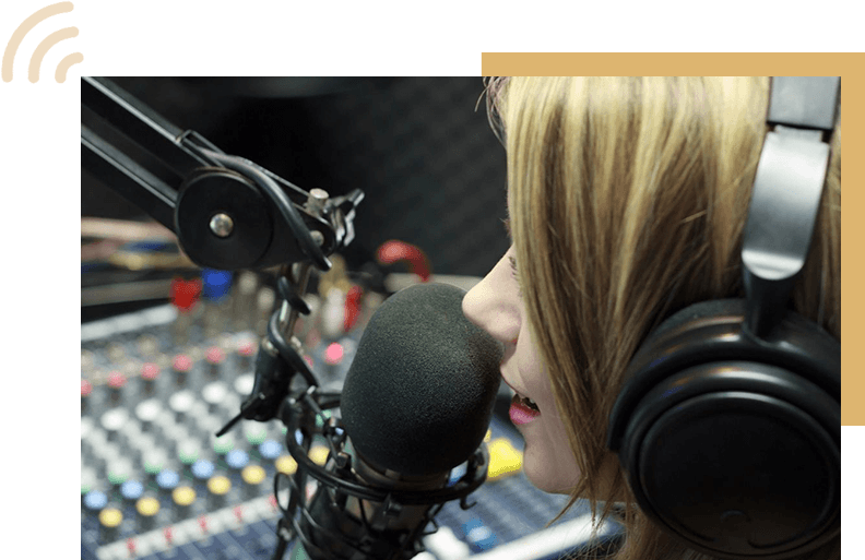 A woman with headphones on talking into a microphone.