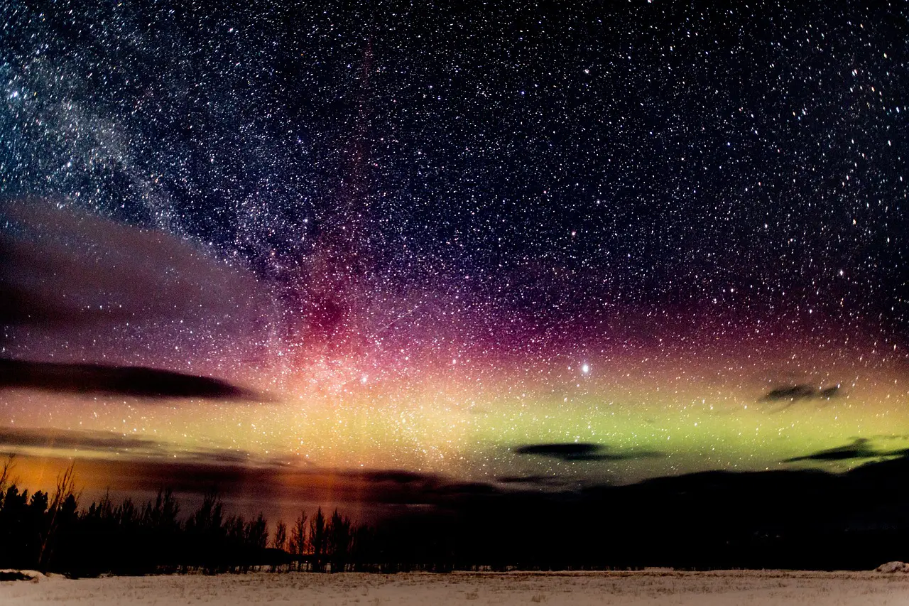 A night sky with the stars and aurora borealis.